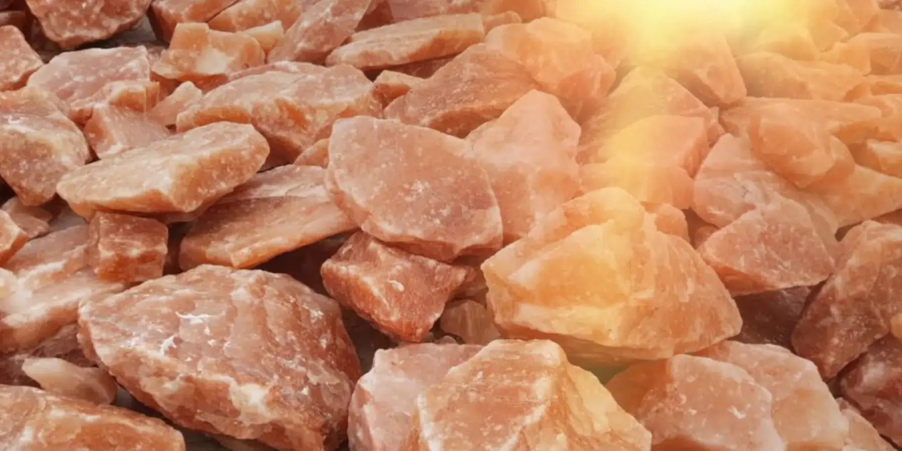 Rough pink salt pieces lit by warm sunlight